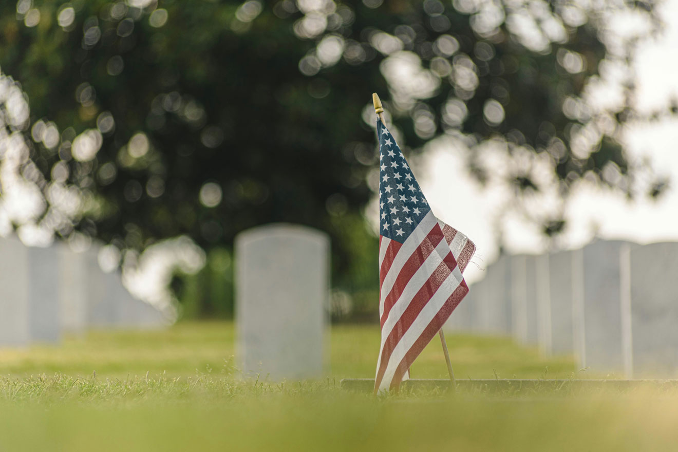 a photo showing a miniature American flag displayed at a military cemetery
